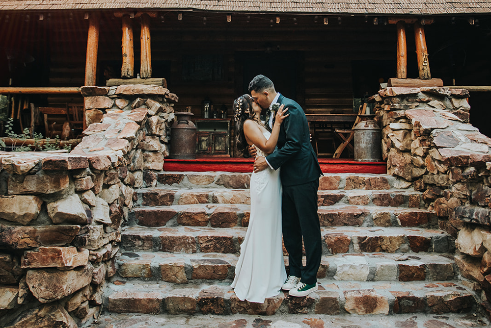 Large gathering of people posed around bride and groom
