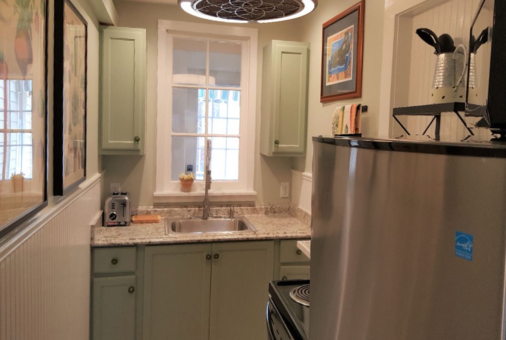 Dining room with table and small countertop next to bedroom and kitchen