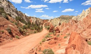 A dirt road winding upwards through a rocky canyon