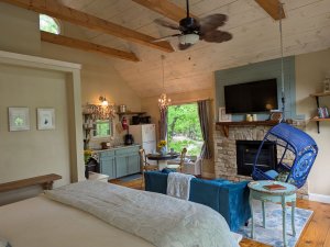 bed with blue spread facing fireplace