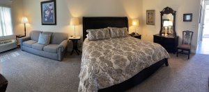 King-sized bed next to lamps and a trundle bed