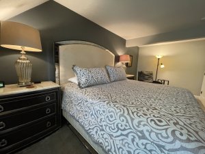 Bed, lamp, and reclining leather seat in bedroom
