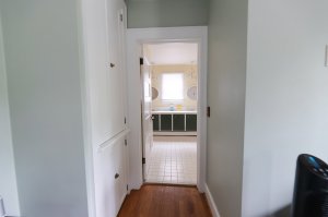 Wall-mounted television, desk, chair, and window across from footer of bed