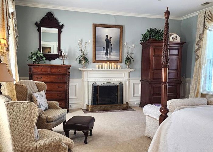 Four poster bed facing a fireplace