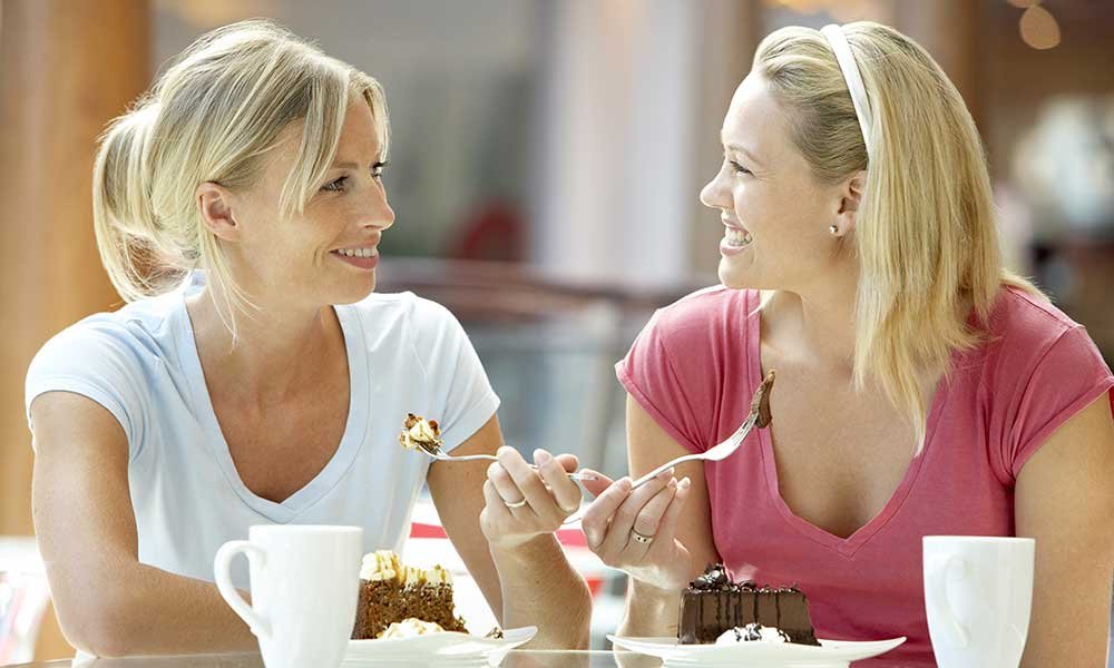 two women talking and eating