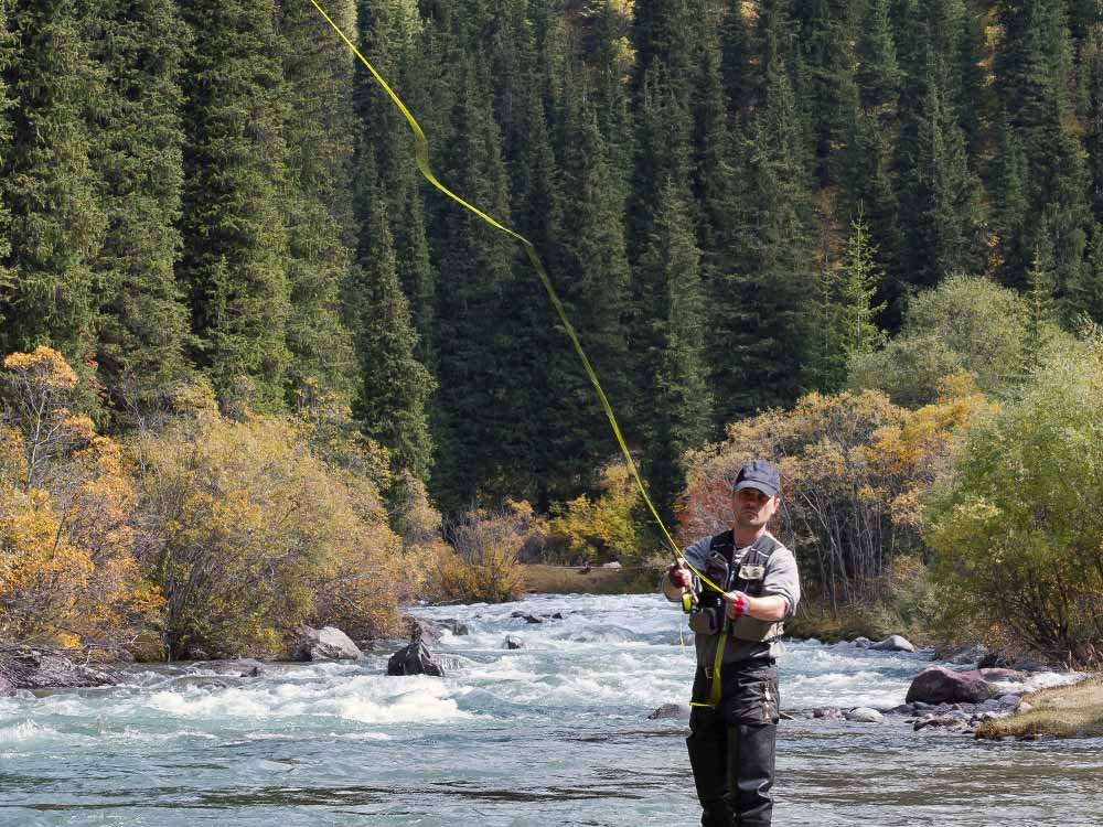 man fly fishing in river